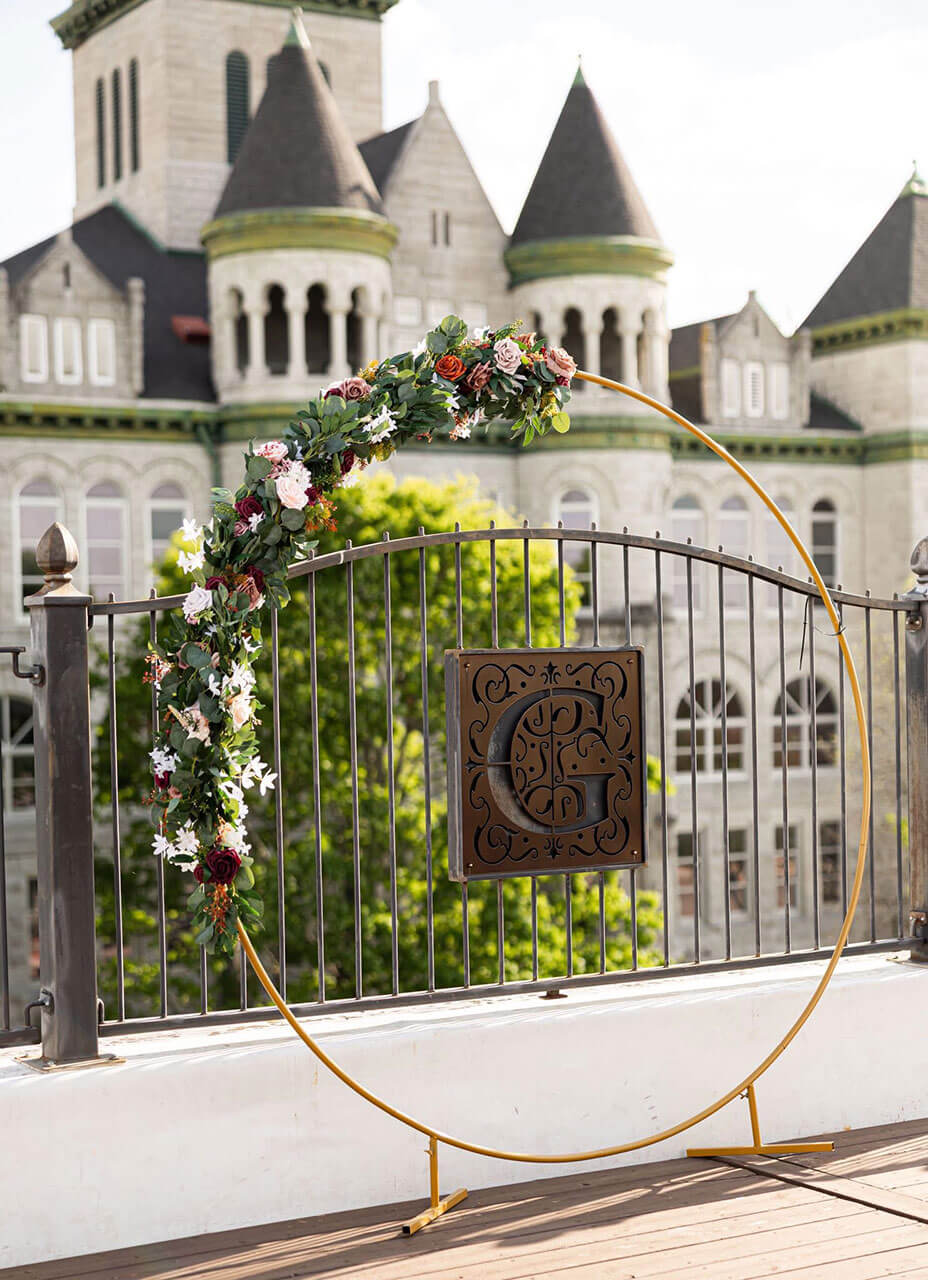 Floral hoop arch with the Gaderian G monogram gate and the courthouse behind