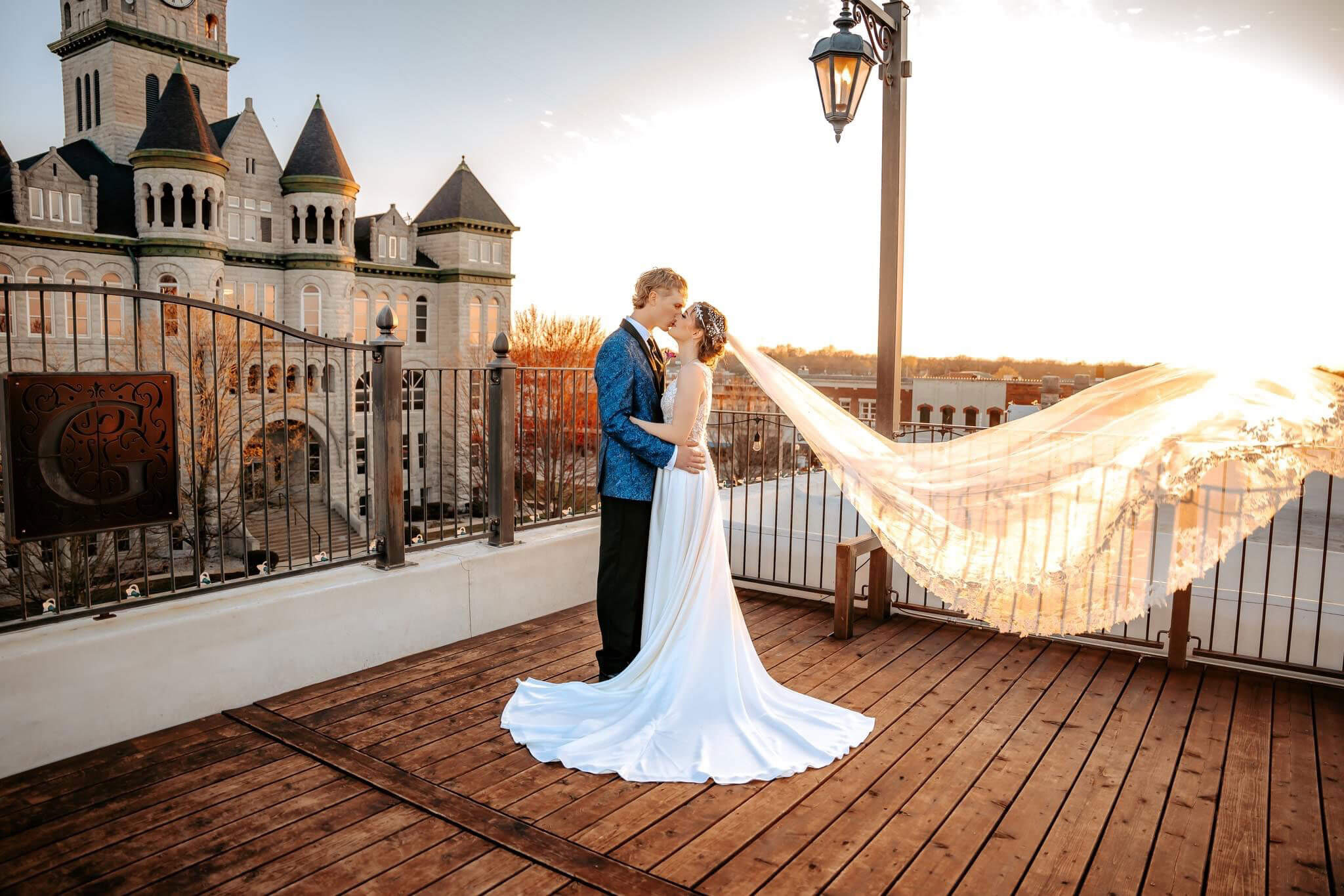 Bride and groom kissing on the rooftop at sunset with the Carthage courthouse behind